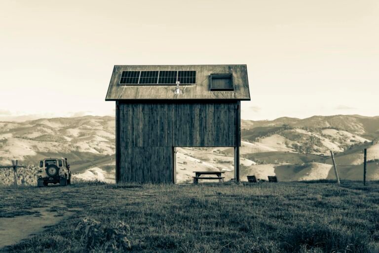 A rustic barn with solar panels, set against rolling hills and a vintage car. Perfect blend of technology and nature.